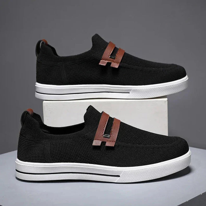 Rovelli black slip-on sneakers with brown accents and white sole on display