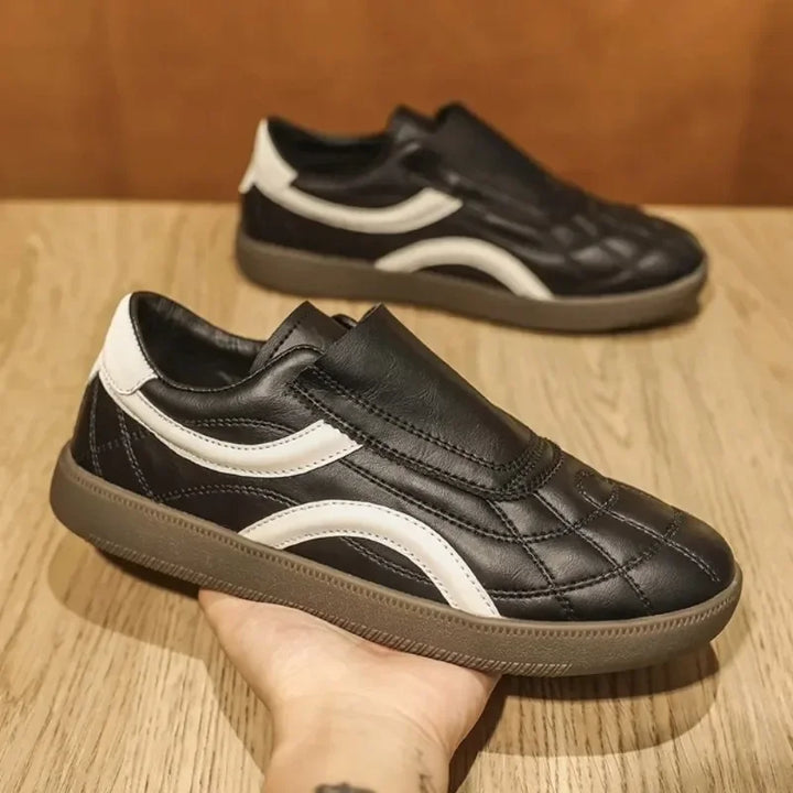 Rovelli black leather casual sneaker with white wave design on wooden surface