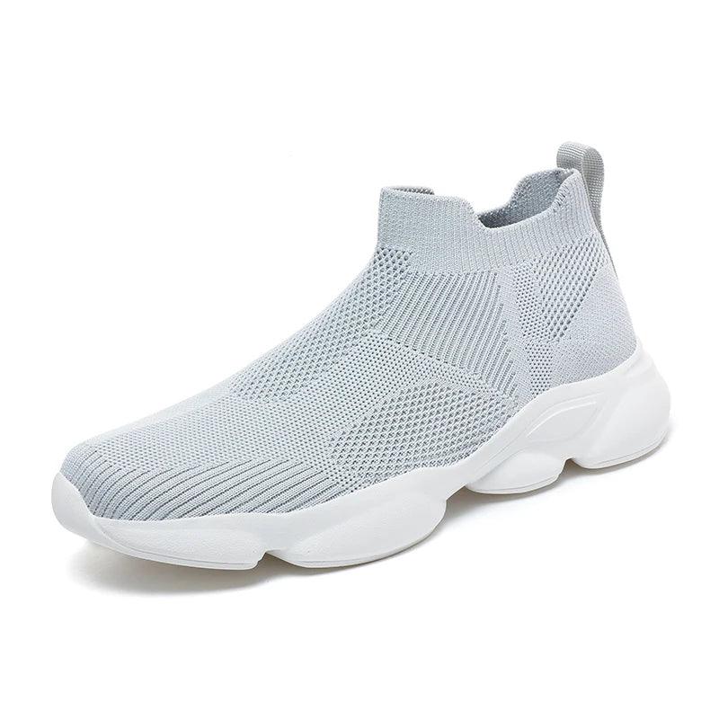 Light gray slip-on athletic sneaker featuring a breathable knit fabric upper, lightweight design, white chunky non-slip sole, and a pull tab at the heel, shown against a white background.