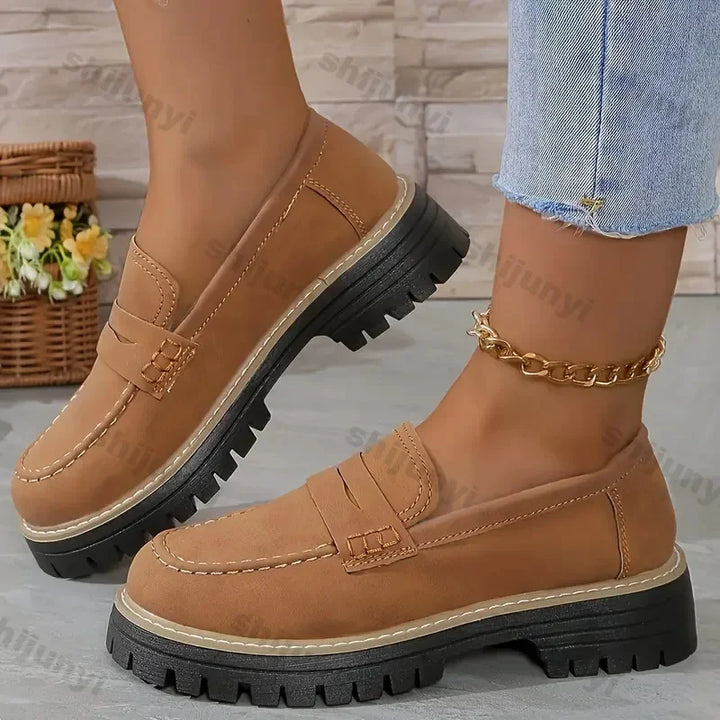 Rovelli tan suede loafers with chunky black soles, worn with jeans, indoor setting