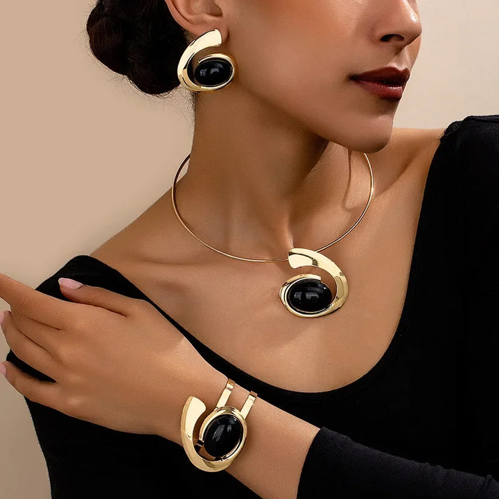 Woman wearing Rovelli gold and black statement jewelry set including necklace, bracelet, and earrings