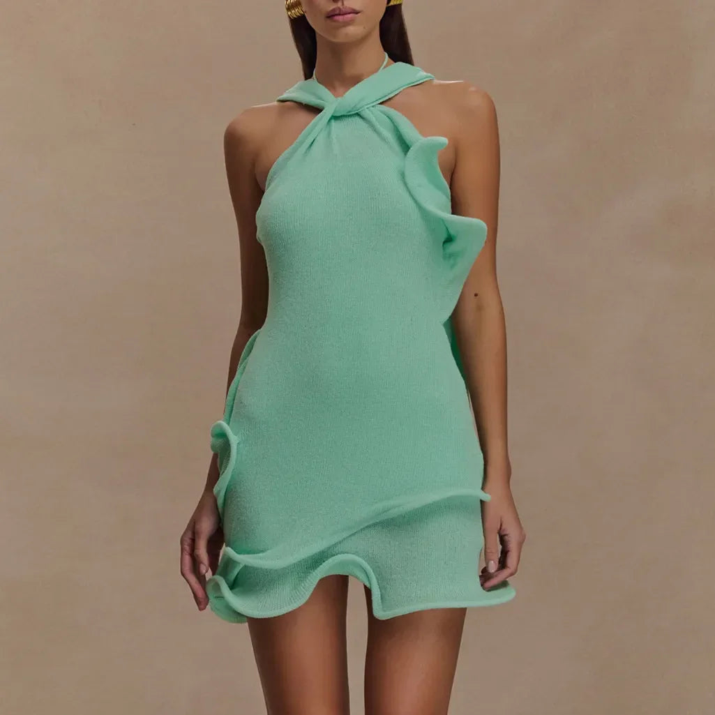 Woman wearing a mint green textured halter mini dress with wavy ruffle details, Rovelli fashion