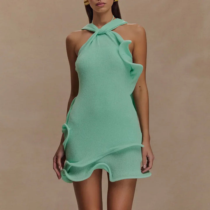 Woman wearing a mint green textured halter mini dress with wavy ruffle details, Rovelli fashion