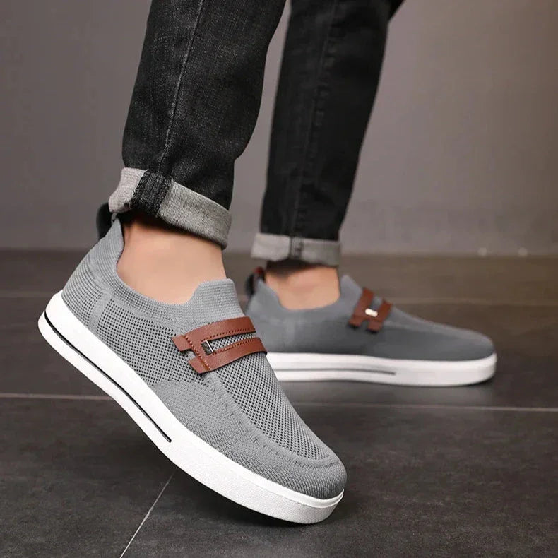 Rovelli gray mesh slip-on shoes with brown detail and white soles, worn with black jeans