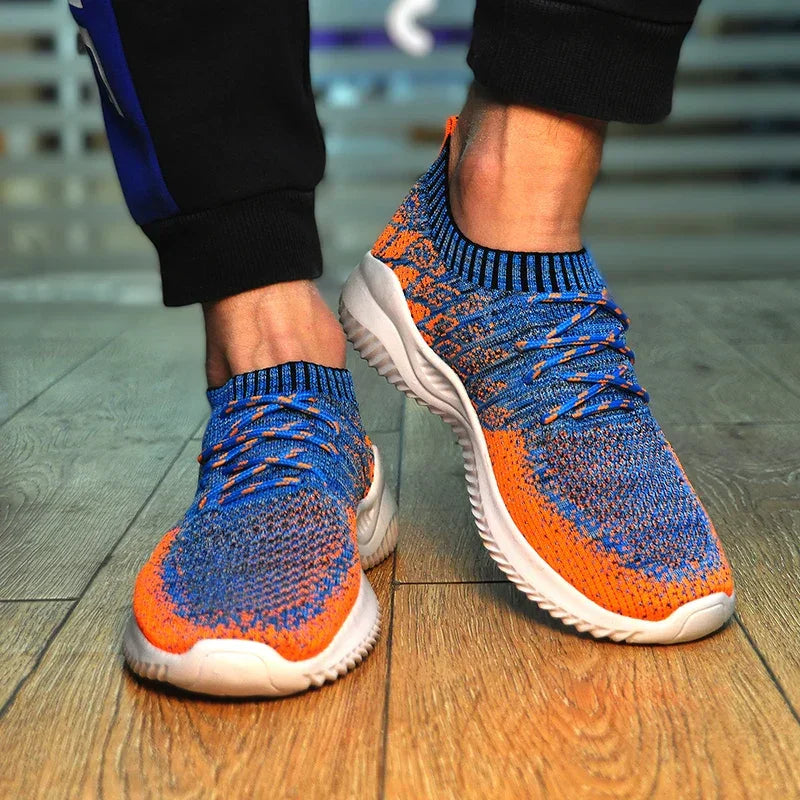 Rovelli blue and orange knit sneakers with white soles on wooden floor