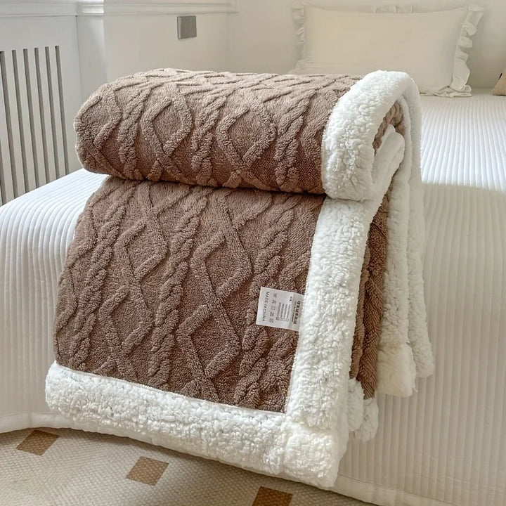 Rovelli textured brown fleece blanket with white sherpa trim on a neatly made bed