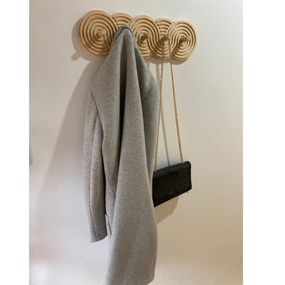 Modern wood coat rack with grey coat and black purse, Rovelli home decor