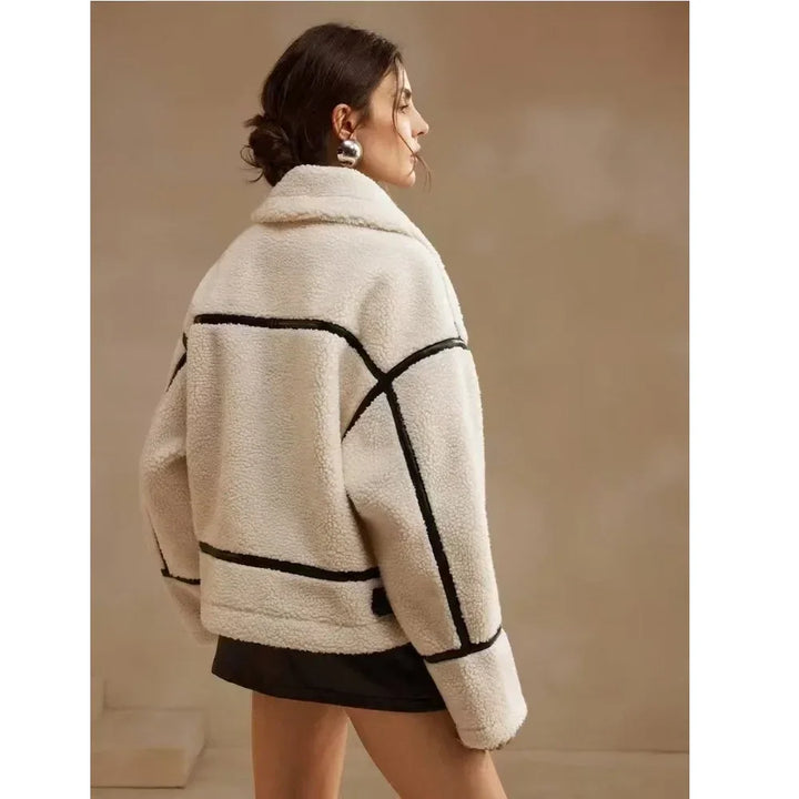 Woman wearing a cream shearling jacket with black trim, Rovelli fashion style