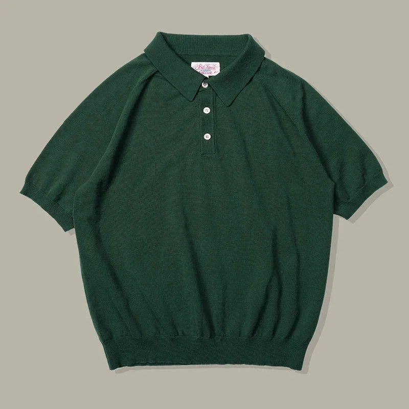 A short-sleeve, dark green classic style polo shirt with a collar, three white buttons, and ribbed cuffs and hem, laid flat on a neutral background.
