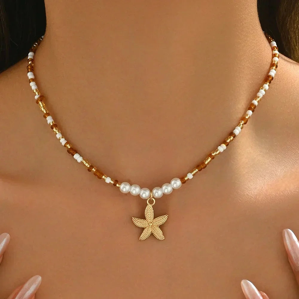 Beaded necklace with gold starfish pendant and pearls on model for Rovelli jewelry