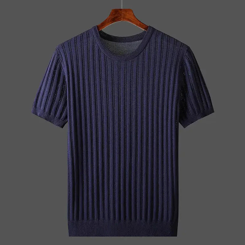 A navy blue, short-sleeved, ribbed knit sweater in a classic fit hangs on a wooden hanger against a plain gray background.
