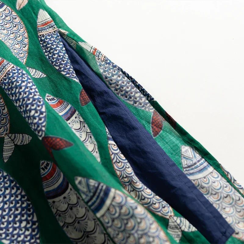 Green fabric with colorful fish print pattern, Rovelli fashion textile detail