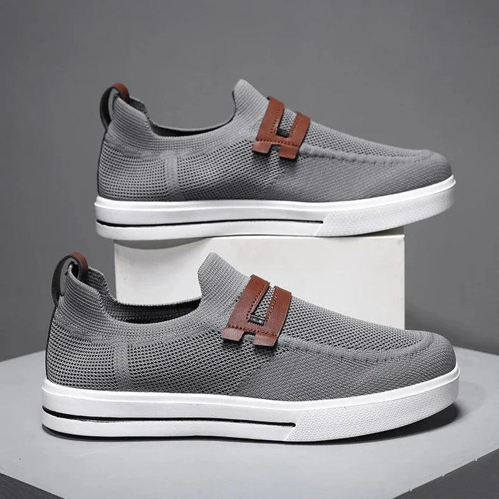 Rovelli grey knit slip-on sneakers with brown strap and white rubber sole on display