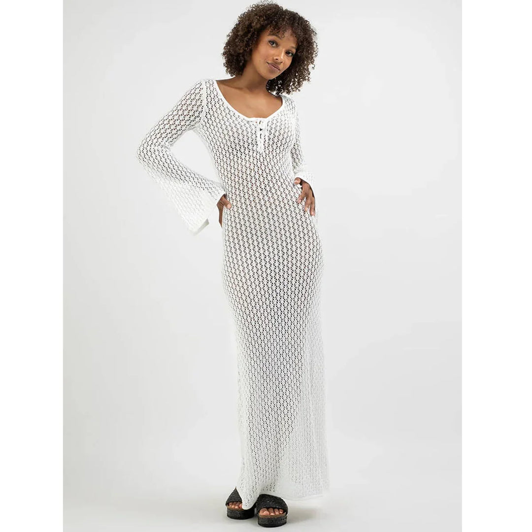 Woman wearing long white crochet dress with flared sleeves, Rovelli fashion