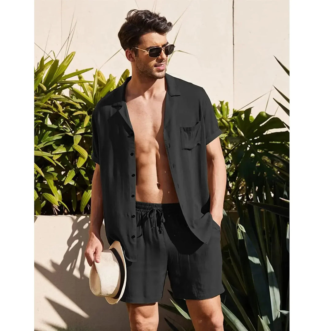 Man in black short sleeve shirt and shorts, holding hat, sunglasses, tropical background, Rovelli fashion
