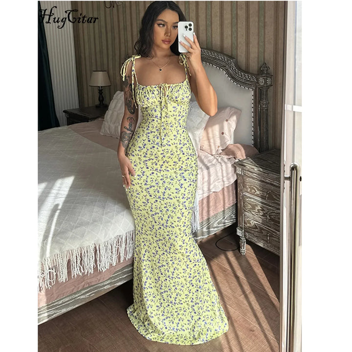 Woman in yellow floral maxi dress taking mirror selfie in elegant bedroom, Rovelli fashion