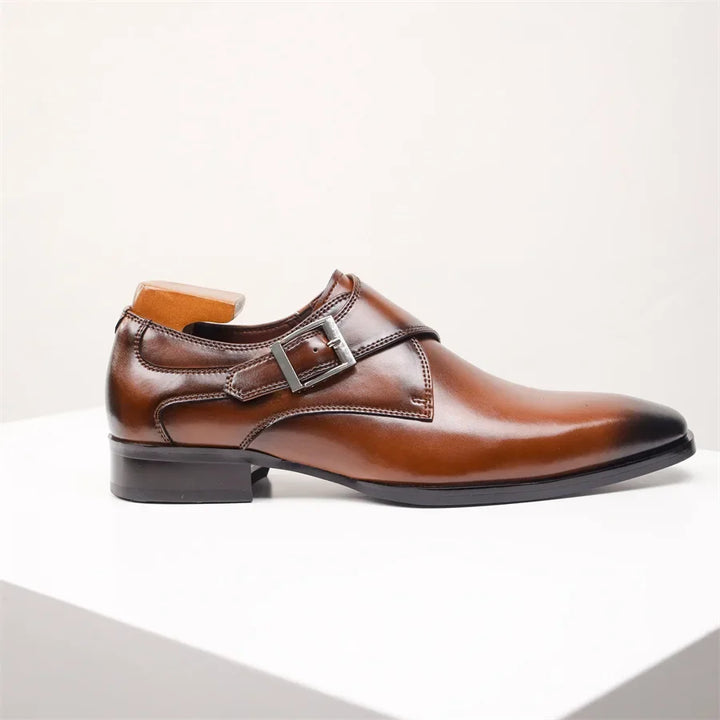 A polished brown Italian leather monk strap shoe with a silver buckle and low heel, displayed on a white surface against a plain light background.