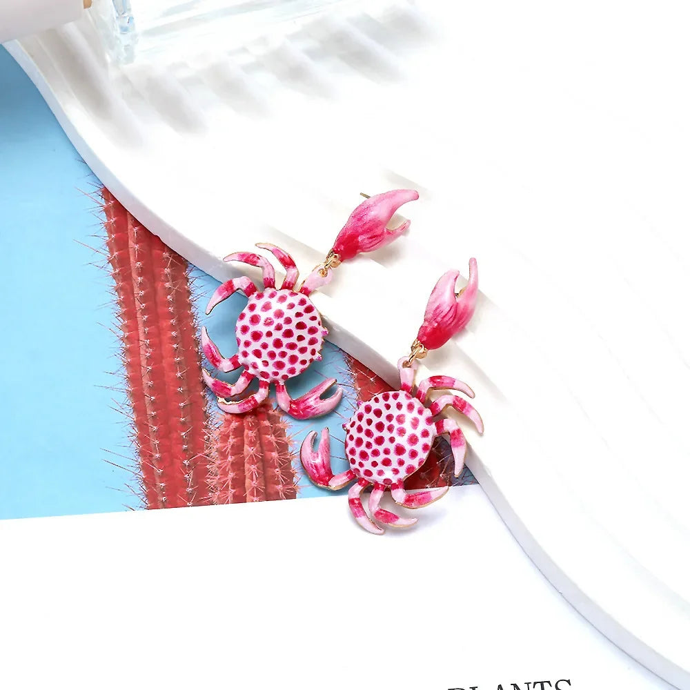 Pink crab-shaped earrings with polka dots on a white tray, Rovelli jewelry accessories