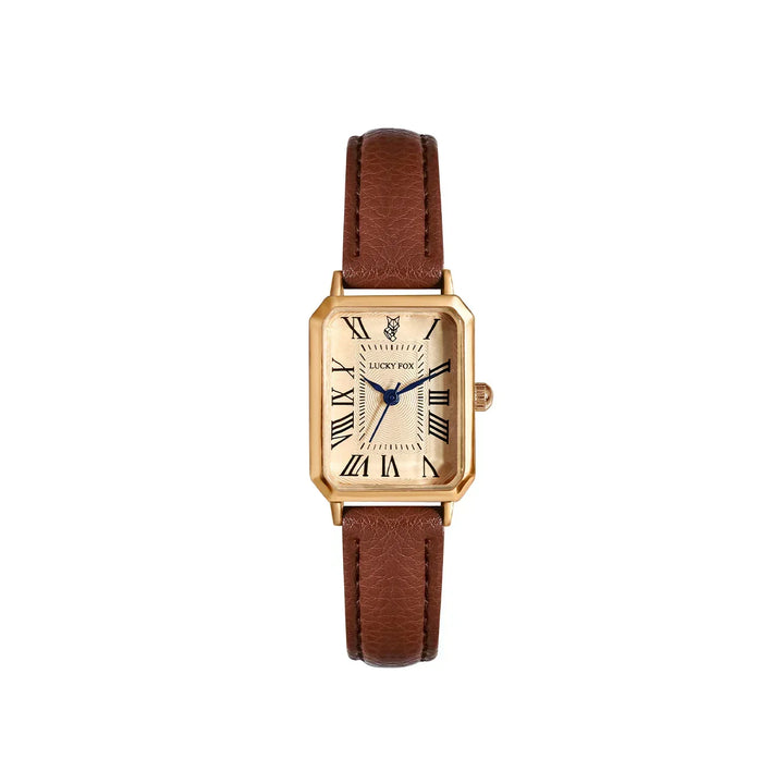 A gold Roman numeral watch with a rectangular face, genuine leather strap in brown, blue hands, and a cream-colored dial. The watch is centered on a plain white background.