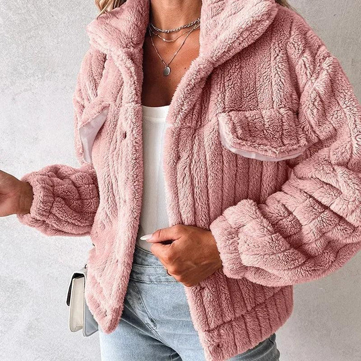 Woman wearing a pink faux fur jacket, white top, and light denim jeans from Rovelli
