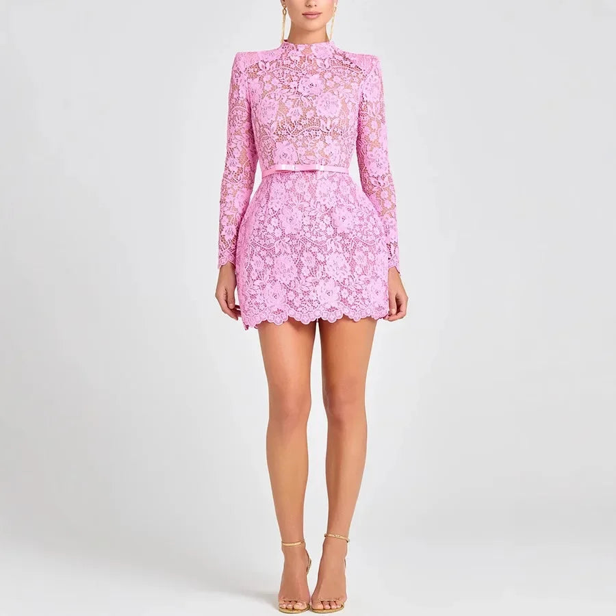 Woman wearing a pink lace mini dress with long sleeves from Rovelli on white background