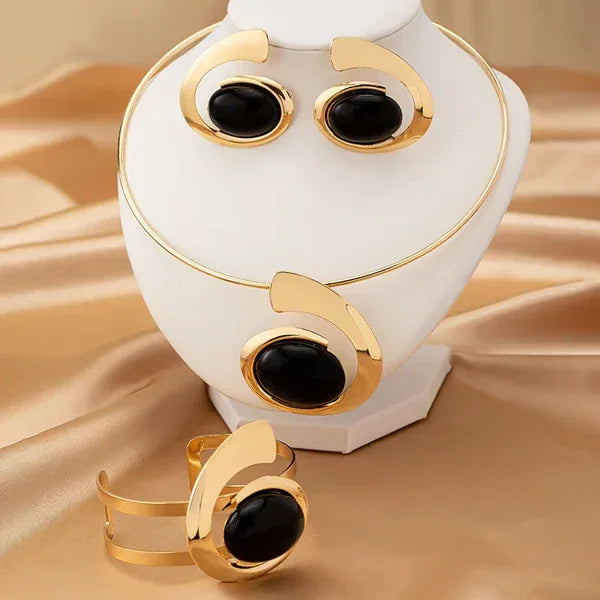 Rovelli gold and black jewelry set with necklace, earrings, and bracelet on satin background
