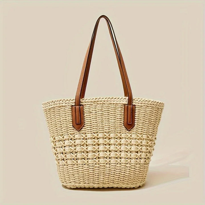 Rovelli woven straw tote bag with brown leather handles against beige background