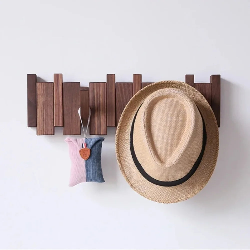 Rovelli wooden wall hook with straw hat and fabric pouch hanging on white wall