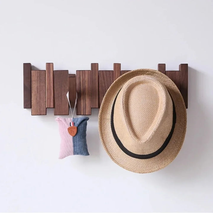Rovelli wooden wall hook with straw hat and fabric pouch hanging on white wall