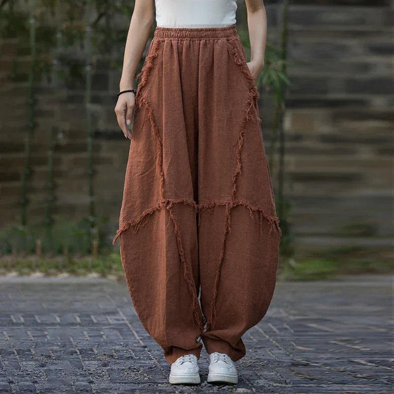 Woman wearing loose brown patchwork pants from Rovelli, outdoor casual fashion style