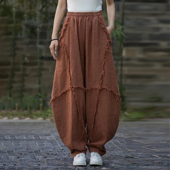 Woman wearing loose brown patchwork pants from Rovelli, outdoor casual fashion style