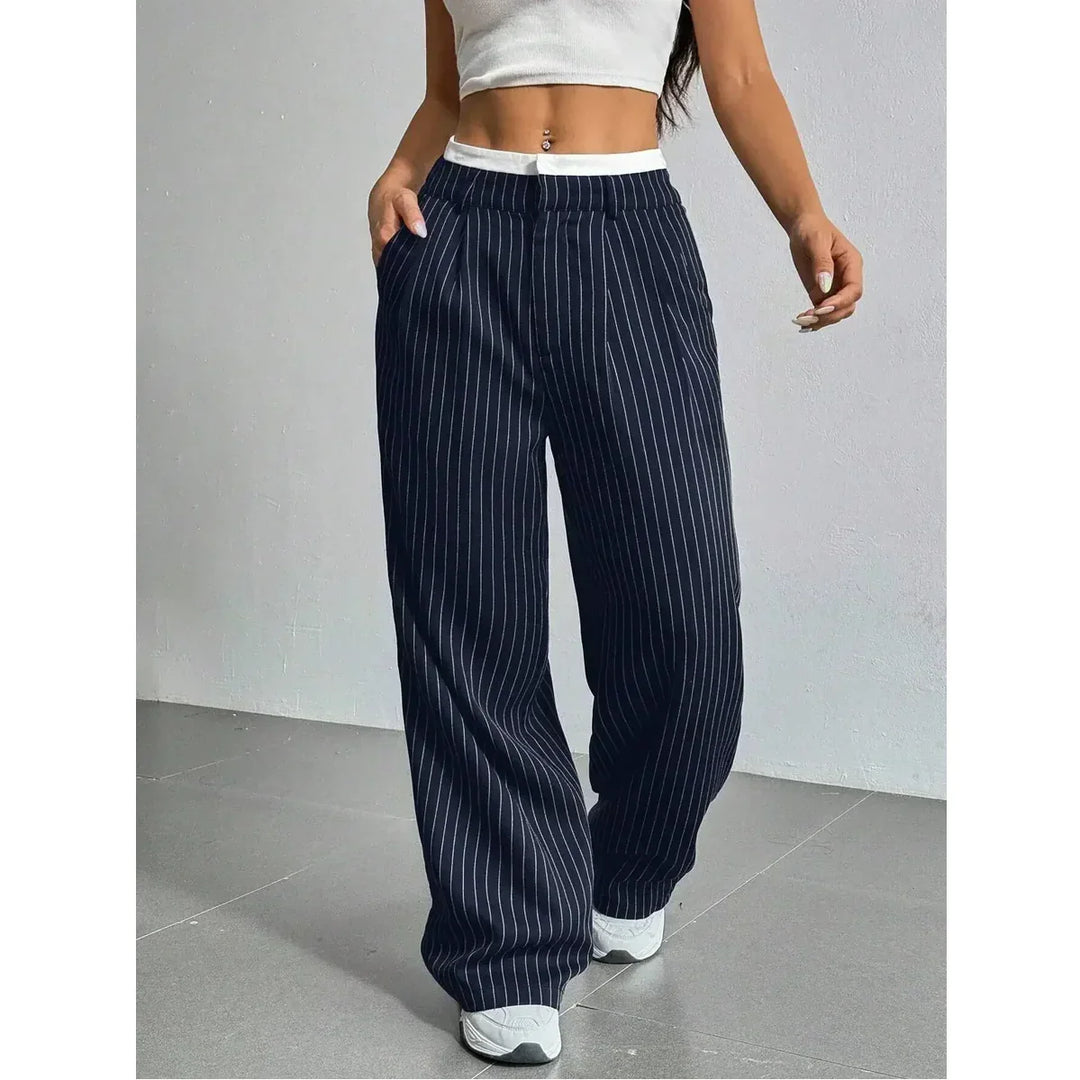 Woman wearing navy pinstripe wide-leg pants, white crop top, and sneakers, Rovelli fashion