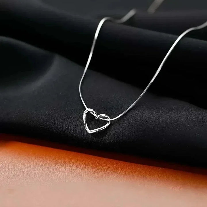 Rovelli silver heart pendant necklace on black fabric, minimalist jewelry design