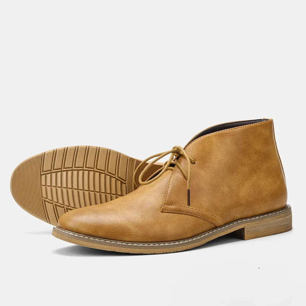 A pair of tan leather After-Ride Chukka boots, one upright and one laying on its side showing the textured sole, against a plain white background.