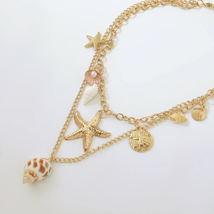 Rovelli gold layered necklace with starfish, shells, and sea-inspired charms on white background