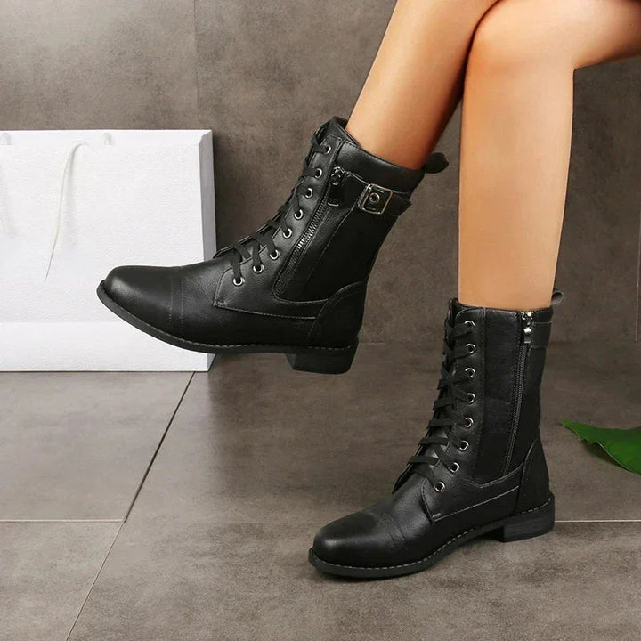 Rovelli black lace-up combat boots with side zipper and buckle on model indoors