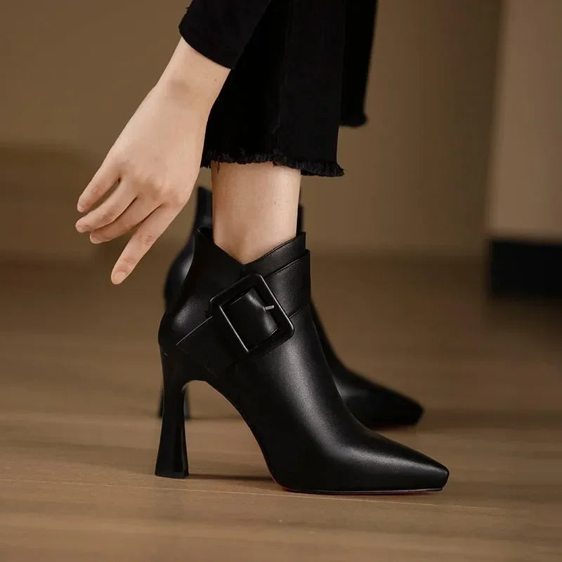 Rovelli black leather ankle boots with buckle detail and high heels on wooden floor