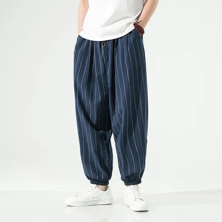 Rovelli relaxed blue pinstripe pants with elastic cuffs, worn with white sneakers and t-shirt