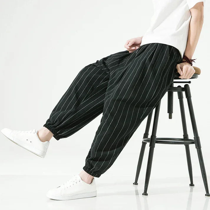 Rovelli black pinstripe relaxed fit pants with elastic cuffs, styled with white sneakers