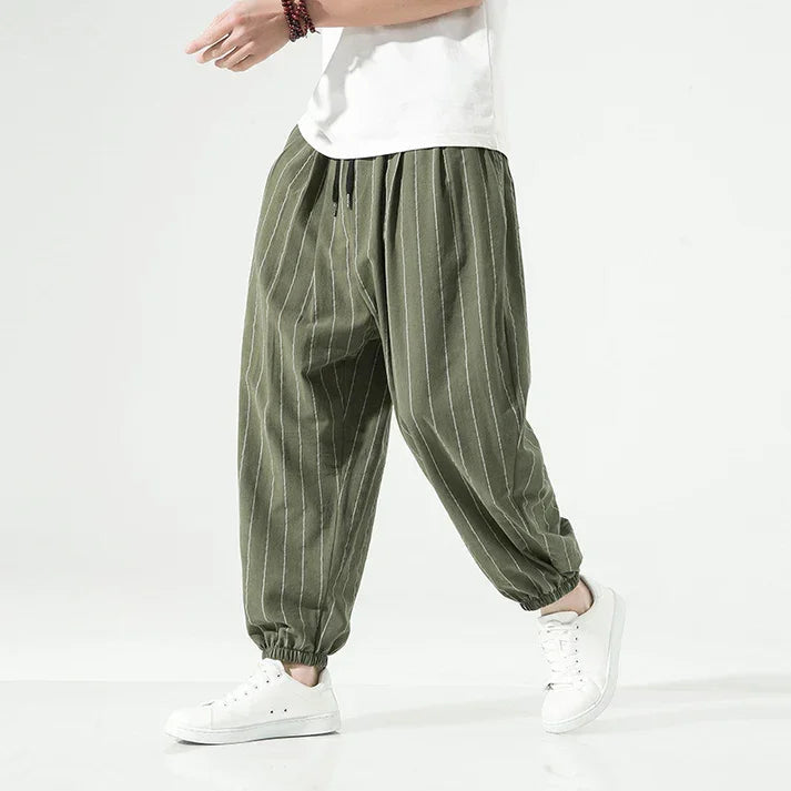 Rovelli green pinstripe jogger pants with elastic cuffs and white sneakers