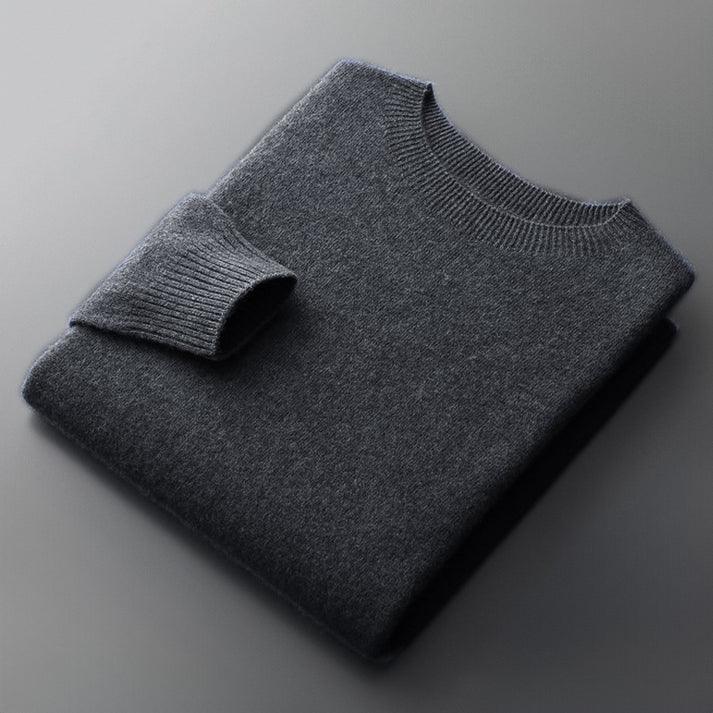 Folded dark gray cashmere sweater with ribbed collar by Rovelli on smooth surface