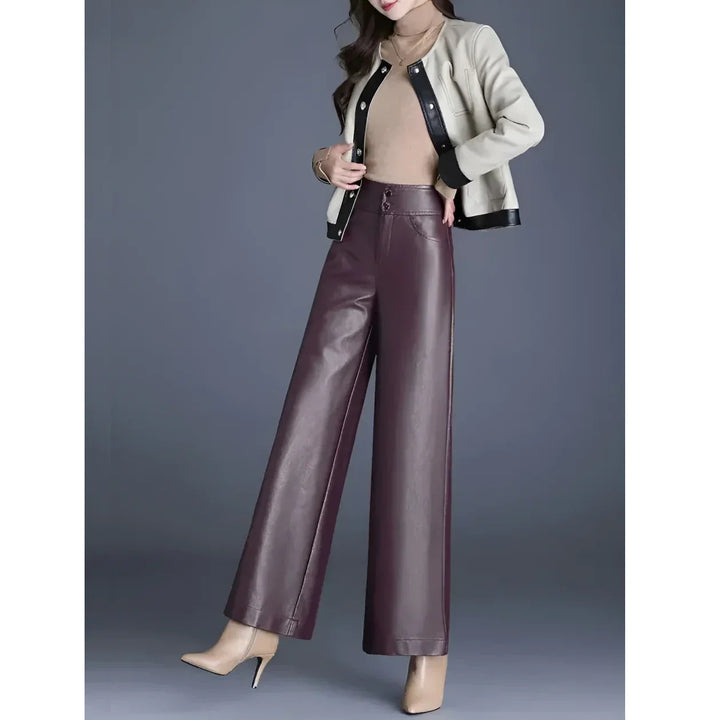 Woman in a beige jacket, brown top, wide-leg maroon pants, and heels, stylish Rovelli fashion