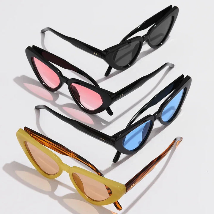 Four pairs of cat-eye sunglasses with black or yellow frames are arranged diagonally. This lightweight eyewear features tinted lenses in black, pink, blue, and light brown, offering UV400 sun protection. Soft shadows fall on the white background.