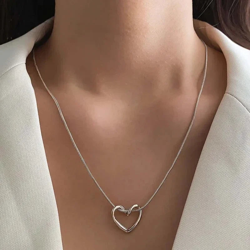 Rovelli silver heart pendant necklace on woman in white blazer