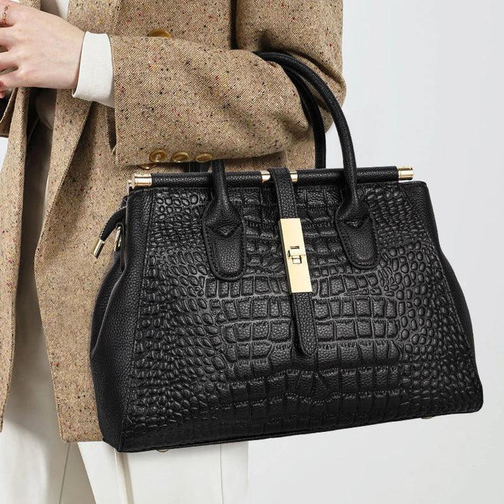 Elegant woman holding black crocodile-embossed Rovelli handbag with gold hardware