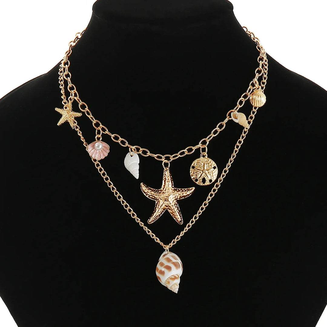 Gold layered necklace with starfish, shell, and sea-inspired charms on black display, Rovelli