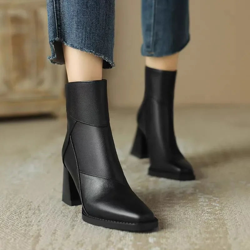 Rovelli black leather ankle boots with block heel styled with cropped jeans on a neutral carpet