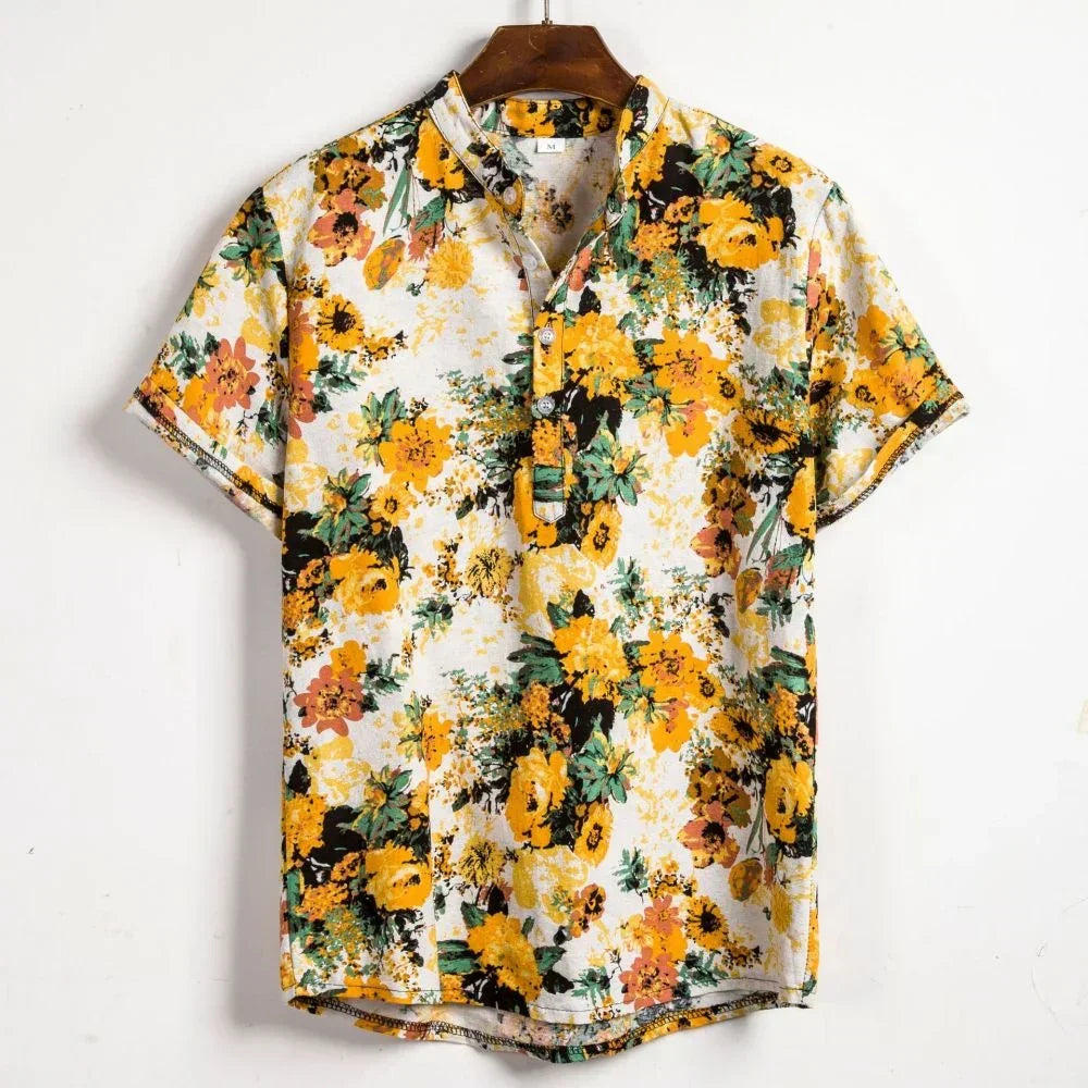 Short-sleeve button-up with a vibrant yellow, orange, and green floral pattern on white—a perfect summer streetwear piece for an oversized fit. Vintage Shirt Men style, displayed on a wooden hanger against a plain white wall.