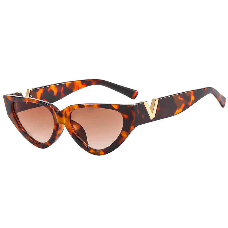 Vintage cat eye sunglasses featuring a bold tortoiseshell frame, brown gradient lenses, and gold V accents on the upper corners, offering stylish UV400 protection.