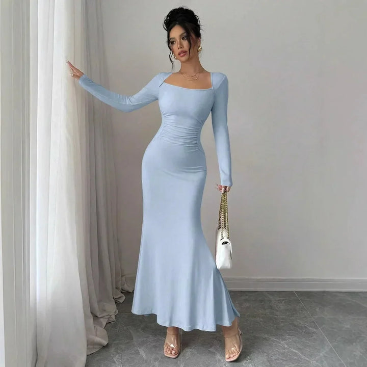 Woman in light blue long sleeve maxi dress holding handbag, Rovelli fashion style